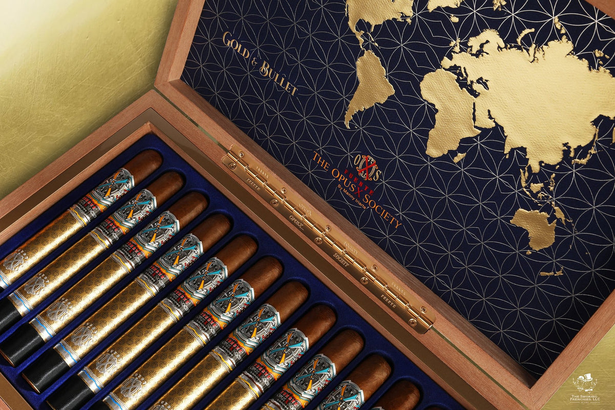 Open Fuente OpusX Gold & Bullet box: cigars in navy velvet slots under a lid with a gold world map and The OpusX Society crest