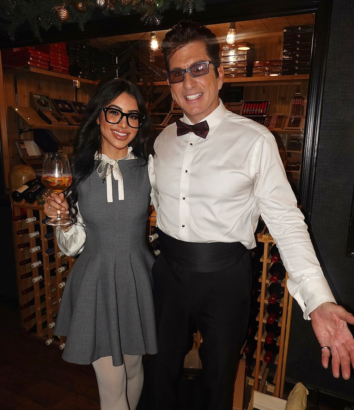 Guests with a glass of wine by the wine racks at Sun of a Gun Cigars & Spirits, Yuma, Arizona