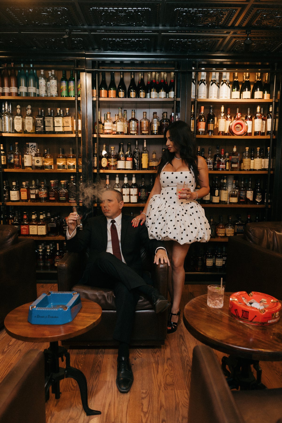 Guests seated before the back bar whiskey wall at Sun of a Gun Cigars & Spirits, Yuma, Arizona