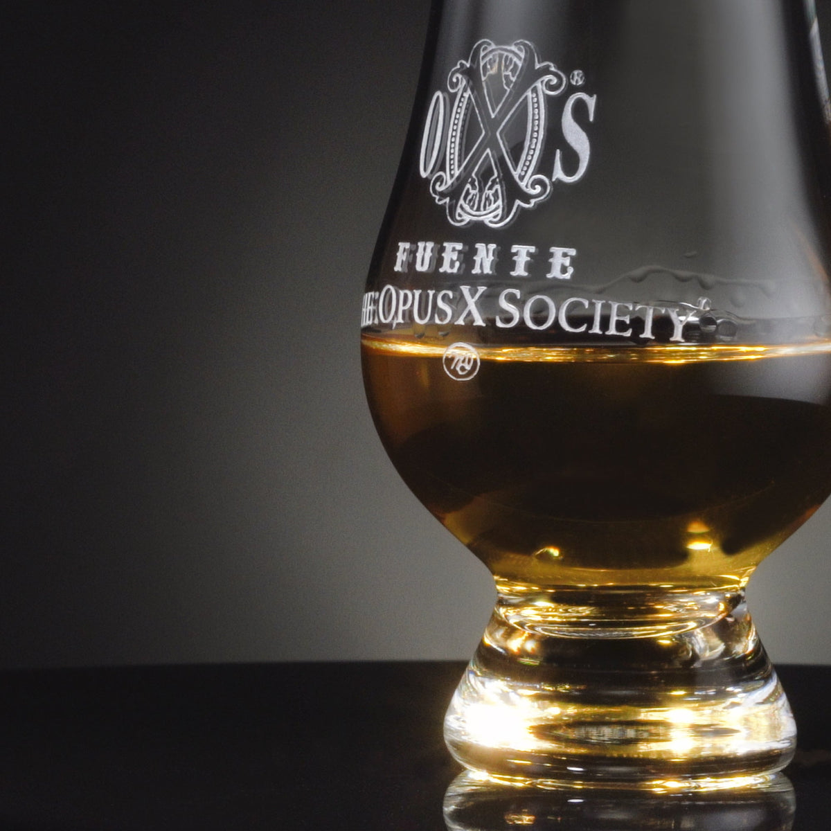 OpusX Society Glencairn glass with a pour of whisky, engraving close-up
