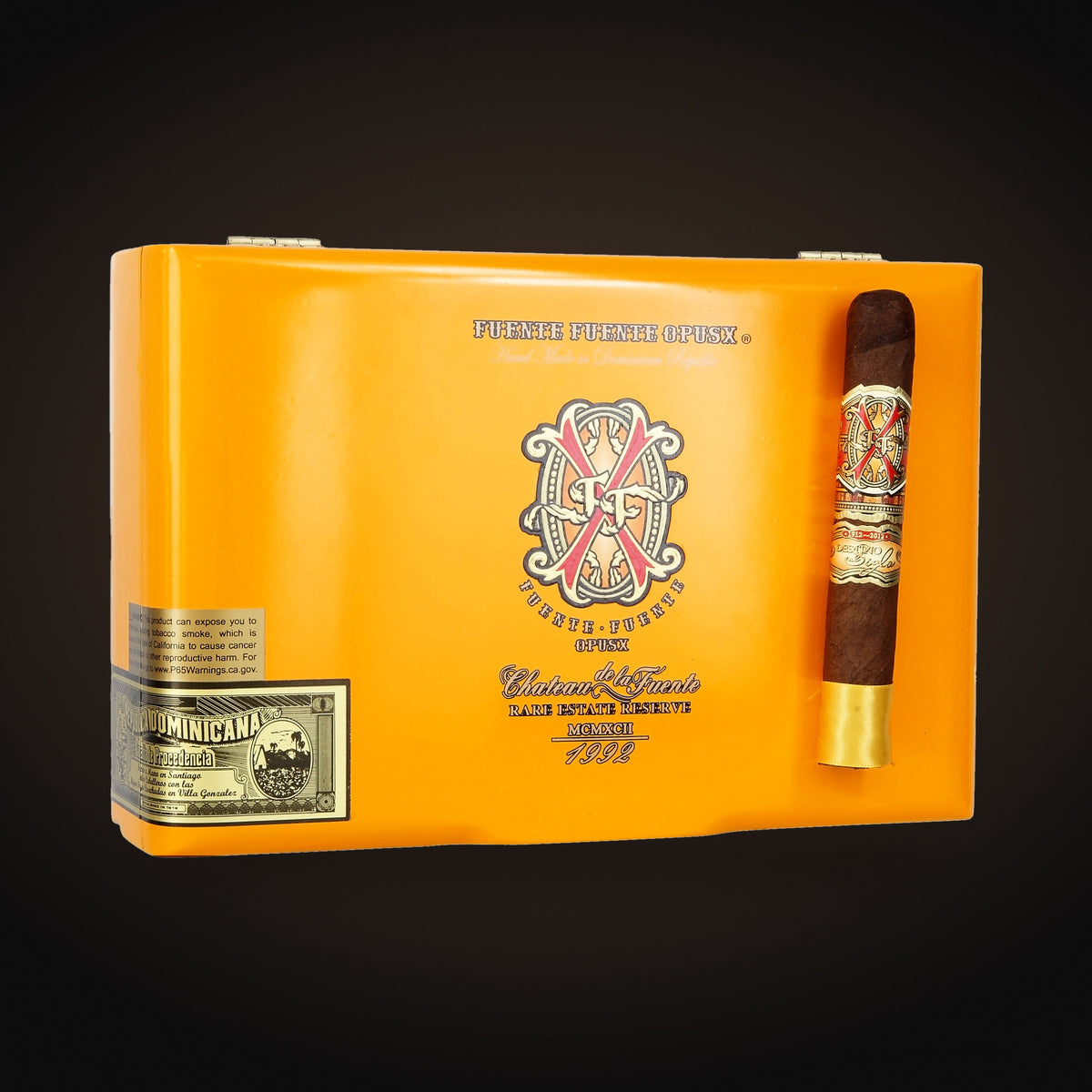 Arturo Fuente Opus X Oro Oscuro Double Robusto, closed box with a cigar beside it — Sun of a Gun Cigars & Spirits, Yuma Arizona