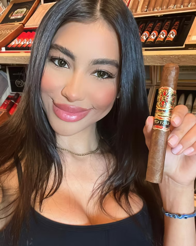 Guest holding a cigar in the walk-in humidor at Sun of a Gun Cigars & Spirits in Yuma, Arizona