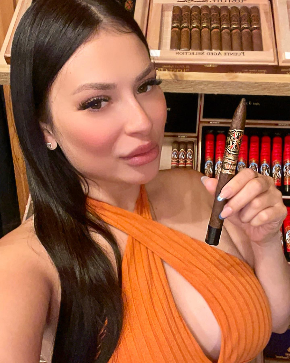 Guest holding a cigar in the walk-in humidor at Sun of a Gun Cigars & Spirits, Yuma, Arizona