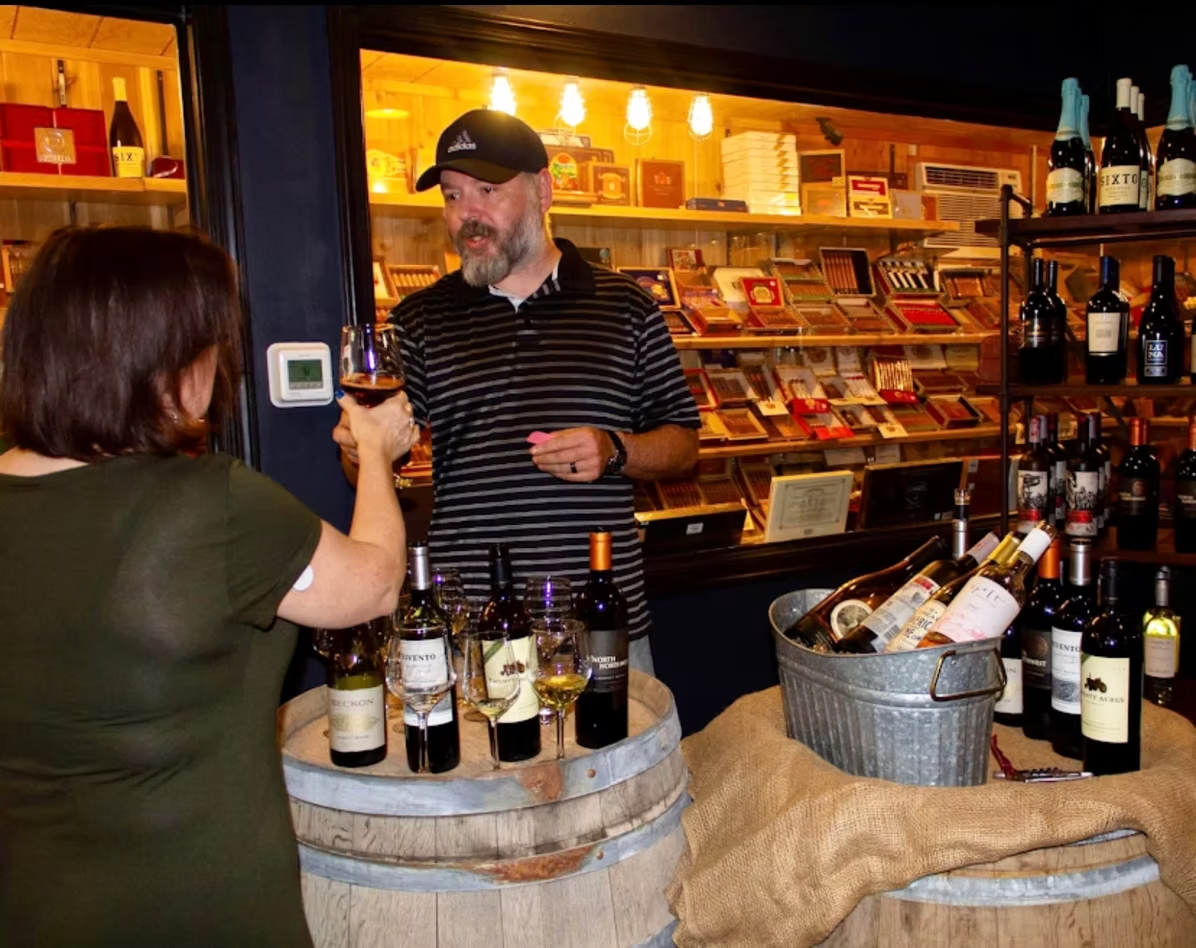 Wine tasting at a barrel table in front of the cigar humidor at Sun of a Gun Cigars & Spirits, Yuma, Arizona