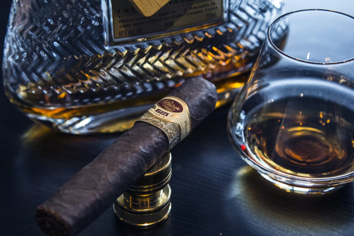 Cigar resting on a crystal ashtray beside a glass of whiskey at Sun of a Gun Cigars & Spirits, Yuma, Arizona