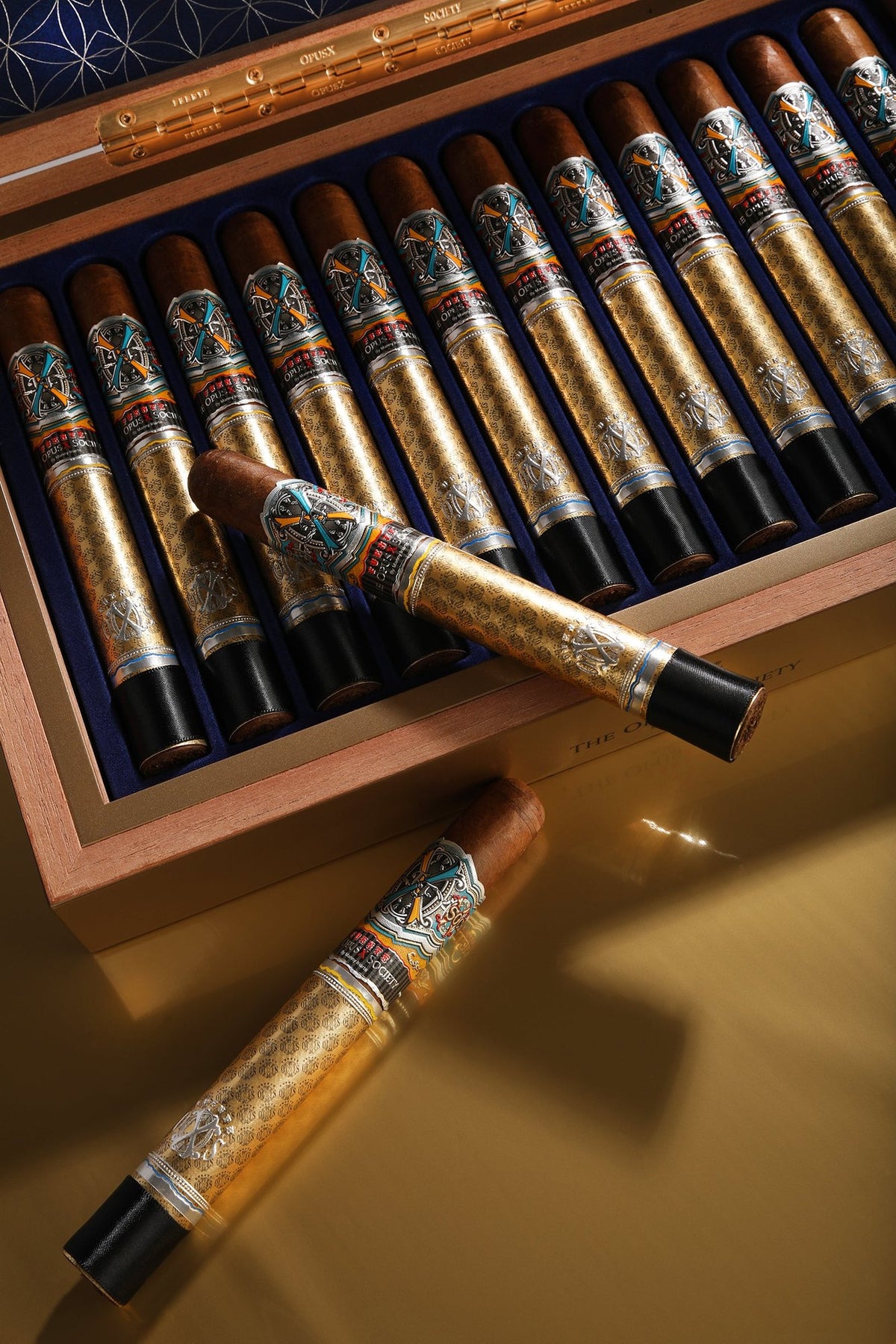 Fuente Fuente OpusX Gold & Bullet: open box of 12 cigars with two cigars resting in front